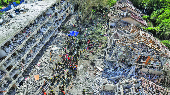 Israeli security forces and first responders gather at the site of an Iranian strike that hit a residential neighbourhood in the Ramat Aviv area in Tel Aviv on June 22, 2025. At least 16 people were hurt and at least one impact was reported in central Israel after Iran launched two waves of missiles at the country following the US bombing of its nuclear sites, rescue services and reports said. (Photo by Jack GUEZ / AFP)